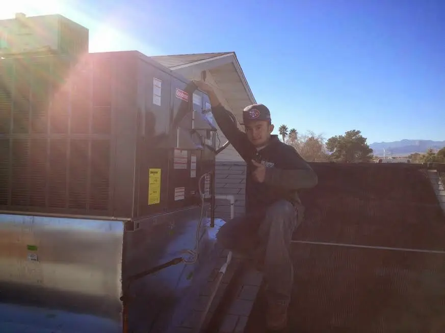 HVAC technician performing AC Tune-Up on a rooftop unit in Byram
